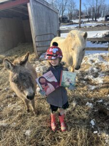 "Call Your Mother" and "If There Never Was a You" held by child with a pony and donkey 